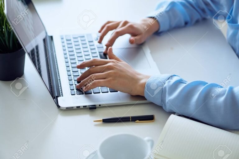 manos trabajando en documentos y computadora